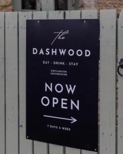 a sign on a fence that says now open at The Dashwood in Kirtlington