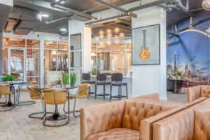 a living room with a couch and a guitar on the wall at CozySuites Modern Midtown Condo 04 in Nashville