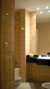 a bathroom with a toilet and a sink and a mirror at Hotel Central in Valdepeñas +57 photos