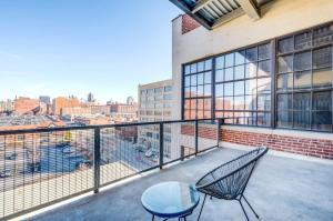 a balcony with two chairs and a table on it at TWO Astonishing Adler Loft by CozySuites in Saint Louis