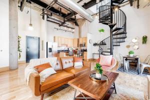 a living room with a couch and a table at TWO Astonishing Adler Loft by CozySuites in Saint Louis