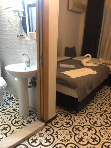 a bathroom with a bed and a sink in a room at Reydel Hotel in Istanbul