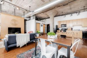 a living room with a table and a couch at TWO Stunning Adler Loft by CozySuites in Saint Louis