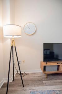 eine Lampe im Wohnzimmer mit einer Uhr an der Wand in der Unterkunft CozySuites The Block - Direct Skybridge Access #1 in Indianapolis