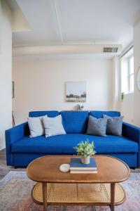 ein blaues Sofa im Wohnzimmer mit Couchtisch in der Unterkunft CozySuites The Block - Direct Skybridge Access #1 in Indianapolis