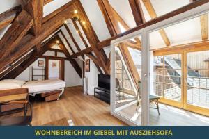 a attic room with a bed and windows at SandAPART34 - 4 tolle FeWos von 1-9 Pers mitten in der Altstadt in Bamberg