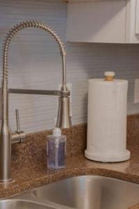 a sink with a faucet and a roll of paper towels at CozySuites The Block - Direct Skybridge Access #2 in Indianapolis