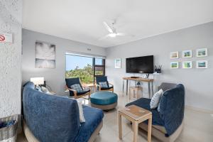 sala de estar con muebles azules y TV de pantalla plana en San Lameer Villa 3706 - 4 Bedroom Superior - 8 pax - San Lameer Rental Agency en Southbroom