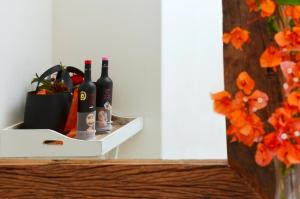 a shelf with bottles of wine and a vase of flowers at Keros Art Hotel in Koufonisia