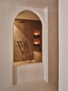 uma casa de banho com um chuveiro e um espelho. em The Wild by Interni em Kalafati