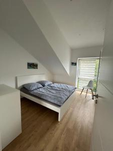 ein Schlafzimmer mit einem Bett, einem Stuhl und einem Fenster in der Unterkunft Panorama Suite 20 in Sinsheim