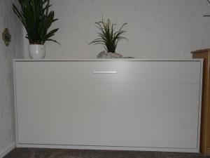 Una cómoda blanca con dos macetas encima. en Gesa Kronenberger, en Scharbeutz