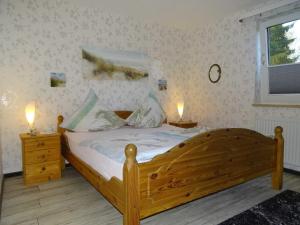 Un dormitorio con una cama de madera con dos luces. en Gesa Kronenberger, en Scharbeutz