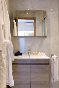 ein Bad mit einem Waschbecken und einem Spiegel in der Unterkunft La Residence Athens in Athen