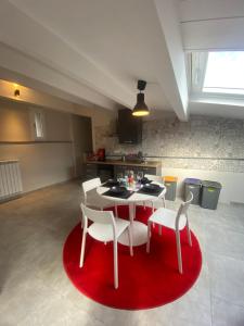een keuken met een tafel en stoelen en een rood tapijt bij Huis Van Wittel in Caserta