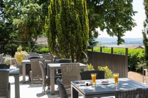 eine Gruppe von Tischen und Stühlen auf einer Terrasse in der Unterkunft l'épicurieux in Chonas-lʼAmballan