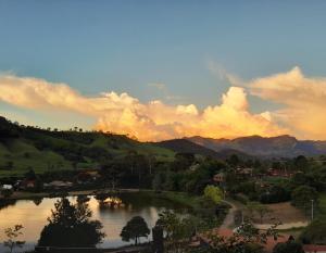 uma vista para um lago com montanhas ao fundo em Casa Estrelada em São Bento do Sapucaí