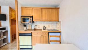 a small kitchen with a sink and a microwave at Résidence Arche - Studio pour 4 Personnes 14 in Flaine