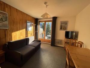 a living room with a couch and a table and a window at Résidence Pollux - Studio pour 4 Personnes 15 in Flaine