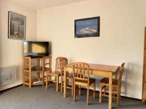 a dining room with a table and chairs and a television at Résidence Pollux - Studio pour 4 Personnes 15 in Flaine