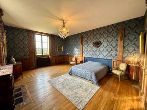 a bedroom with a bed and a chandelier at Gîte baroque château Pervenchère in Casson