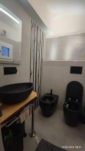 baño con lavabo negro y aseo en Centro storico di Bologna via Petroni, en Bolonia