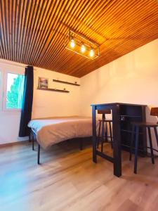 1 dormitorio con cama, escritorio y mesa en BEL APPART rénové en face des universités, en Brunstatt