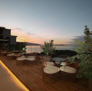 a balcony with chairs and tables and a sunset at Sunset Apartment in Vlorë