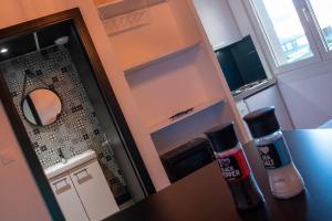 una pequeña cocina con encimera y espejo en BEL APPART rénové en face des universités, en Brunstatt