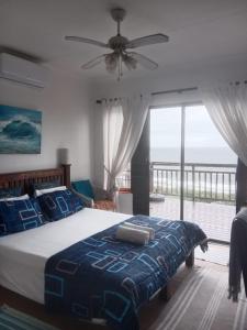 a bedroom with a bed with a view of the ocean at Bayview Guest House in Amanzimtoti
