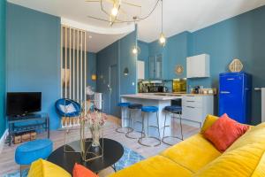 a living room with a yellow couch and a kitchen at Hamac Suites - Le Mercière - Centre Lyon II -6pers in Lyon