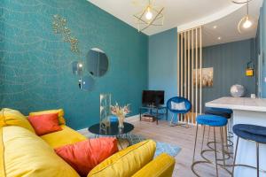 uma sala de estar com um sofá amarelo e paredes azuis em Hamac Suites - Le Mercière - Centre Lyon II -6pers em Lyon