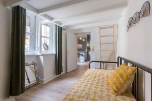 um quarto com uma cama com uma almofada amarela e uma janela em Hamac Suites - Le Mercière - Centre Lyon II -6pers em Lyon