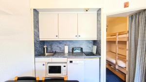 a small kitchen with a sink and a refrigerator at Résidence Andromede - Studio pour 4 Personnes 19 in Flaine