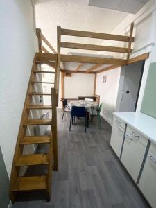 uma cama alta num quarto com uma mesa e uma cozinha em Résidence Ramond - 2 Pièces pour 5 Personnes 314 em Barèges