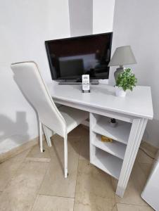 una scrivania bianca con sedia bianca e TV di B&B Villareale 35 a Palermo