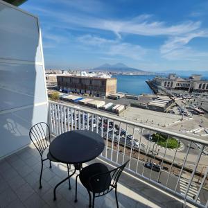 a balcony with a table and chairs and a view of a city at Hotel Bella Capri in Naples