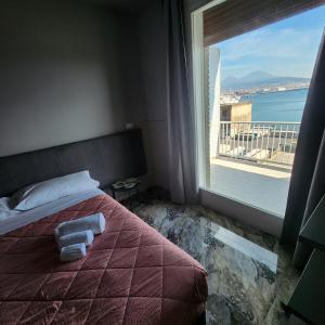 a hotel room with a bed and a large window at Hotel Bella Capri in Naples