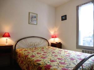 - une chambre avec un lit avec un couvre-lit floral et deux lampes dans l'établissement Résidence Balcons De Bareges - 2 Pièces pour 5 Personnes 344, à Barèges