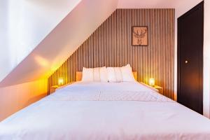 a bedroom with a large white bed with two lamps at Cocon de Luchon - Station de ski accessible à pied in Luchon