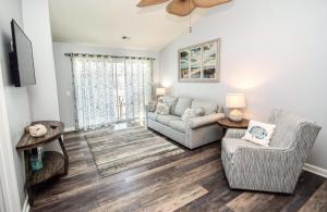 a living room with a couch and two chairs at Waterway Village by Palmetto Vacations in Myrtle Beach