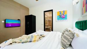 a bedroom with a bed and a tv on a wall at BluO Vasant Vihar PVR - Terrace Garden, Lift in New Delhi
