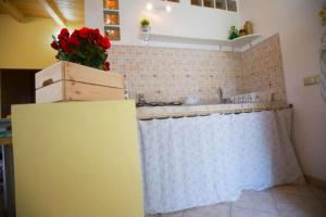 a kitchen with a refrigerator with a flower on top of it at The Cottage in Mascalucia