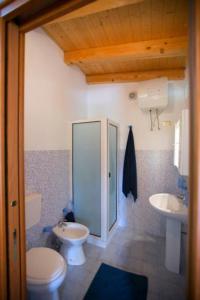 a bathroom with a toilet and a sink at The Cottage in Mascalucia
