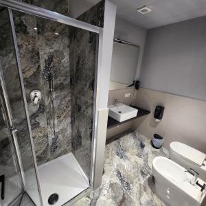 a bathroom with a shower and a toilet and a sink at Hotel Bella Capri in Naples