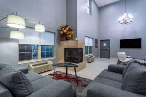 a living room with two couches and a fireplace at Ramada by Wyndham Sellersburg/Louisville North in Sellersburg