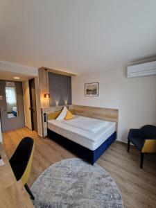 een hotelkamer met een bed en een stoel bij Hotel Restaurant Esser in Wegberg