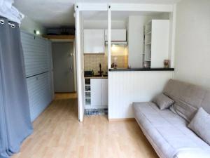 Una sala de estar con un sofá y una cocina. en Résidence Ayre - Studio 4 couchages avec place de parking couvert proche du centre de Barèges MAE-8474, en Barèges