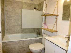 Un baño con bañera, inodoro y lavabo. en Résidence Ayre - Studio 4 couchages avec place de parking couvert proche du centre de Barèges MAE-8474, en Barèges 3 fotos más