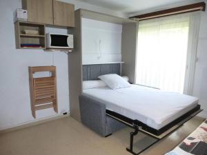 a small bedroom with a bed and a microwave at Résidence Neouvielle - Beau studio dans le centre de Barèges MAE-8484 in Barèges